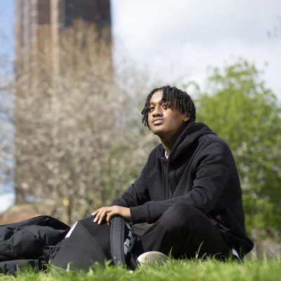 Young person sitting in the park with bags