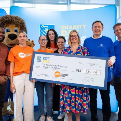 Staff at the Royal Bank of Canada hold a giant cheque after their fundraising event, celebrating the $135,000 USD raised