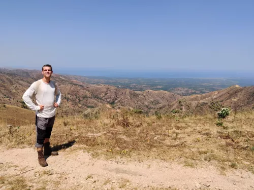 Photograph of Ben Harris, fundraiser, outside with a mountainous horizon in the background.