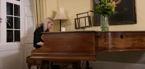 Young person playing a grand piano