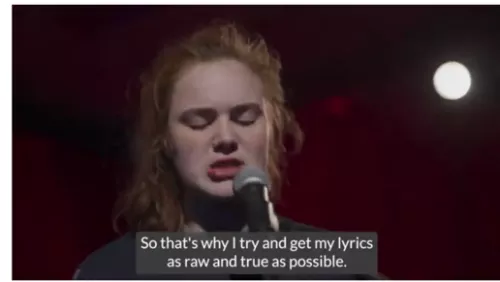 Young person with red hair in front of a microphone