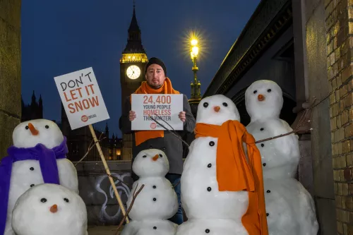 Snowmen outside the Houses of Parliament in London, with placards reading 'Don't Let It Snow'