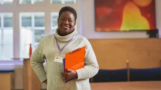 Centrepoint stands with a smile clutching a clipboard.