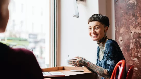 Young person sat at a desk by a window