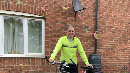 Ged stands with his bike in his back garden on an overcast day