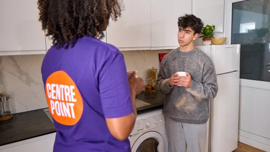 Carim speaking to a key worker in a Centrepoint service kitchen