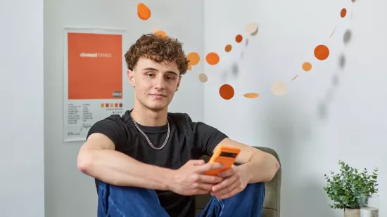 A young person sits in his Centrepoint room looking relaxed