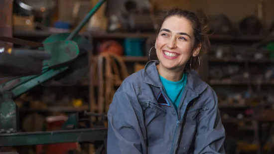 Young female working as mechanic in blue overalls