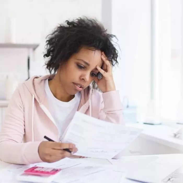 Young person sat in kitchen looking at paperwork