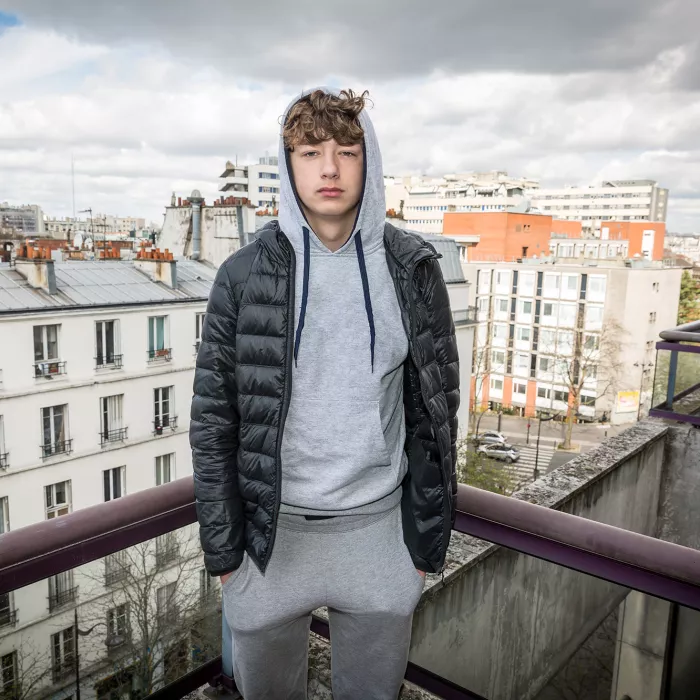 Young person on balcony overlooking cityscape