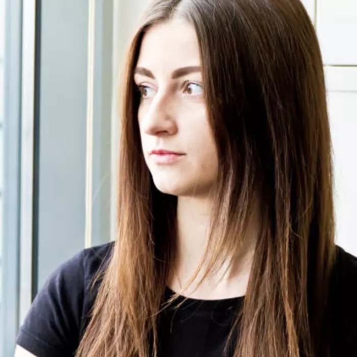 A young woman looks out a window.