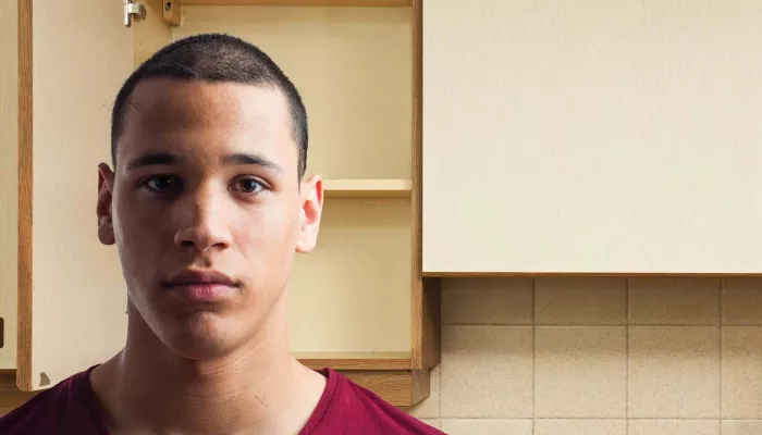 Young person in kitchen staring to camera