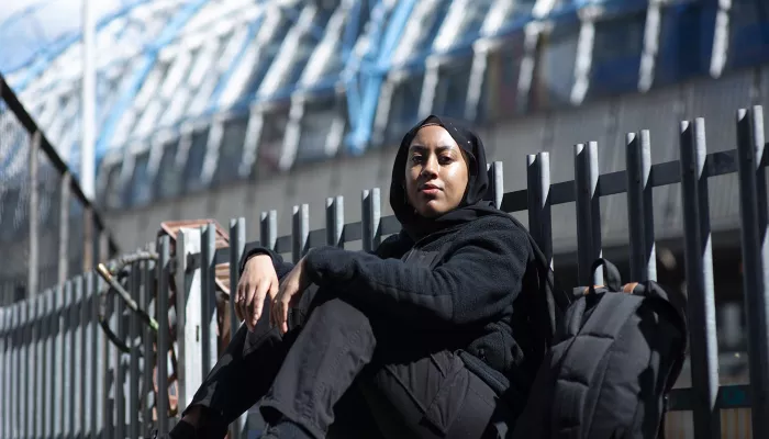 Young person sitting outside with backpack