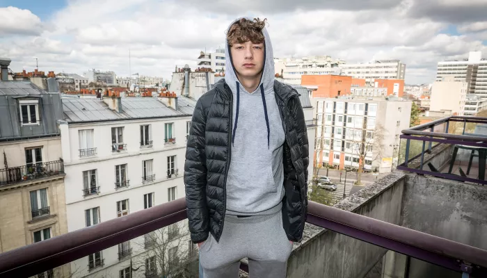 Young person on balcony overlooking cityscape