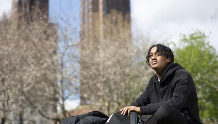 Young person in a park with a backpack