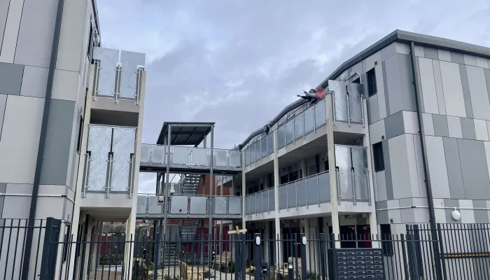 A block of new, affordable flats within a secure gated community. Each flat has its own front door and there is shared outside space in the middle of the block.