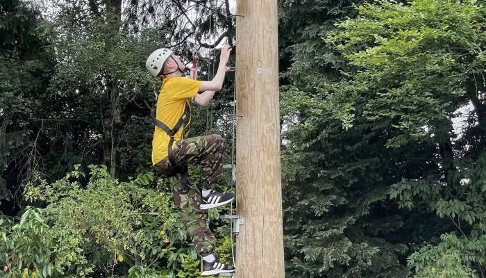 Young person climbing a long post