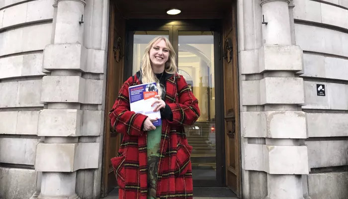 Frankiebo Taylor from the policy team at Centrepoint, holds our latest report outside Lambeth Town Hall