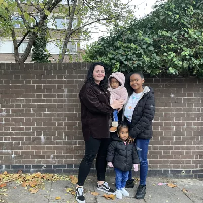 Young woman standing outside with her two young daughters and her key worker