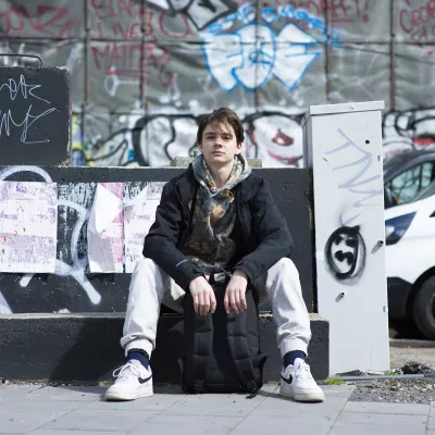 Young person sat down on street side