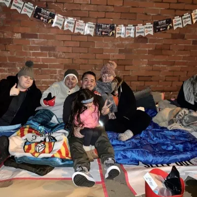 Group of adults lie on the floor in sleeping bags 