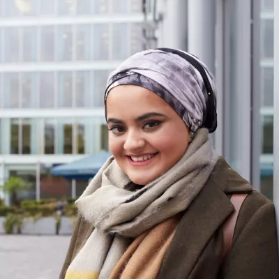 Young person in front of office buildings