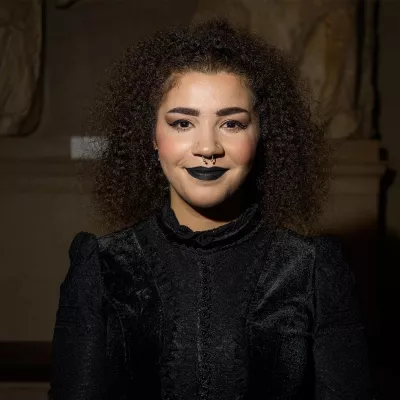 Young person in black dress smiling