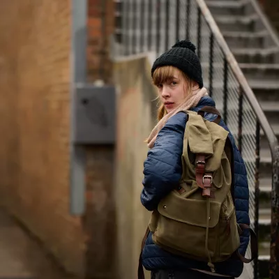 Anna looking back, over her shoulder in an alley way